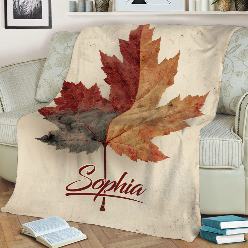 Fall leaf throw blanket draped over a sofa, featuring rich autumn foliage in red and orange tones
