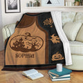 Halloween throw blanket draped over a sofa with witch, pumpkin, haunted house, and spiderweb artwork