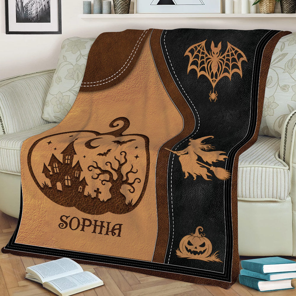 Close lifestyle view of a Halloween blanket featuring a witch, jack-o'-lantern, bats, and haunted house design