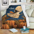Halloween throw blanket draped over a sofa with a ghost witch, pumpkins, bats, and full moon design