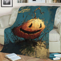Jack-o'-lantern Halloween throw blanket displayed on a sofa in a cozy living room setting