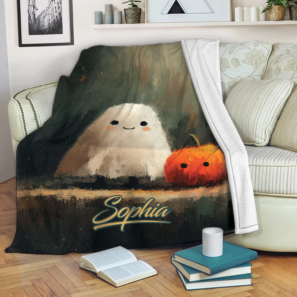 Halloween ghost and pumpkin throw blanket displayed on a cozy sofa with books and home decor