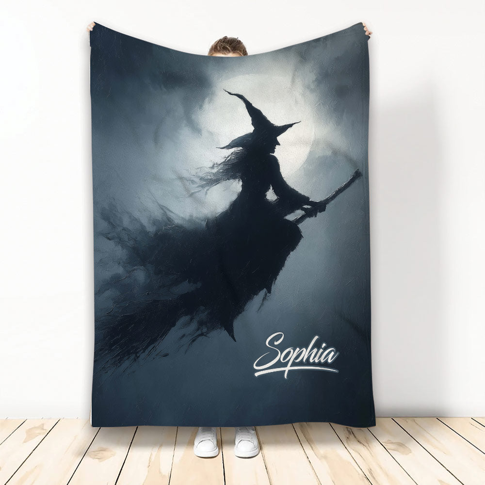 Halloween blanket with a witch silhouette flying across a full moon in a dark blue night scene