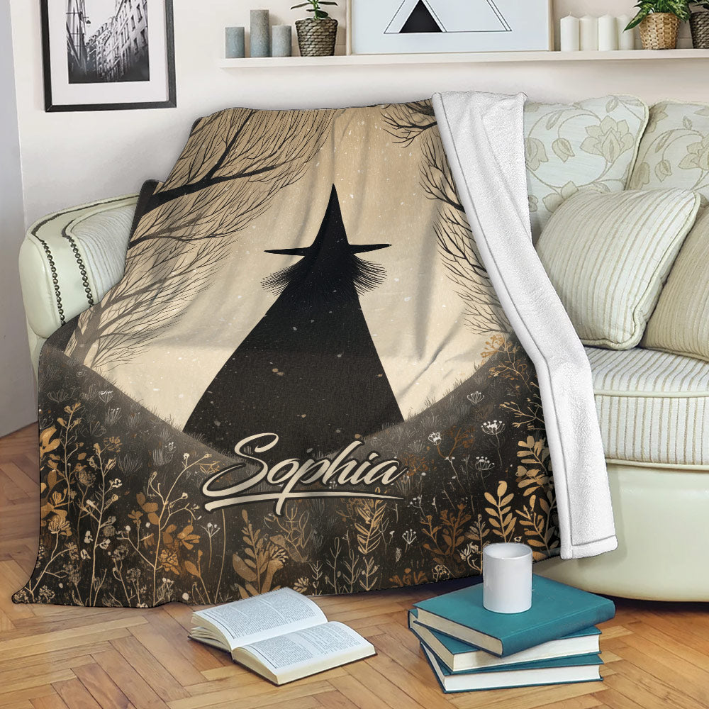 Halloween throw blanket draped over a sofa with spooky witch and woodland artwork