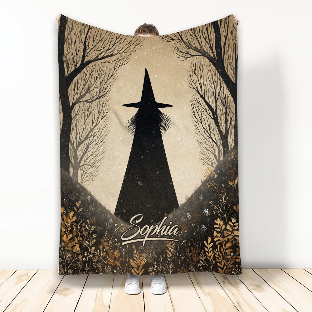 Halloween blanket with a black witch silhouette, bare trees, and warm autumn woodland artwork