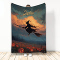 Halloween blanket featuring a flying witch on a broom over glowing pumpkins and a dramatic autumn sky