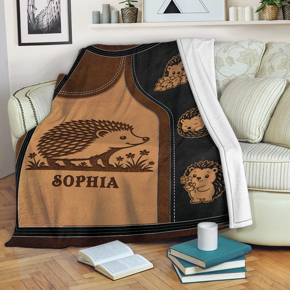 Hedgehog blanket draped over a sofa, showing a large hedgehog and smaller floral hedgehog illustrations