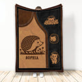 Hedgehog throw blanket displayed upright with woodland artwork in warm brown and black tones
