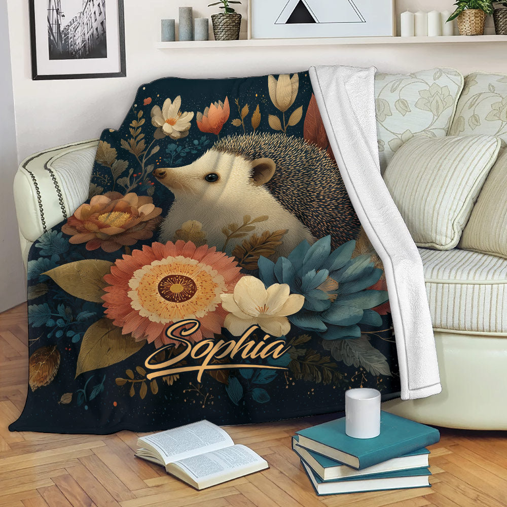 Hedgehog throw blanket displayed on a sofa with floral woodland artwork