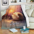 Hedgehog blanket draped over a sofa with a starry woodland illustration and cozy reading scene