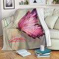 Pink butterfly throw blanket displayed across a cozy living room sofa