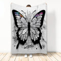 Butterfly throw blanket with intricate black-and-white wings and colorful accents displayed in a bright room