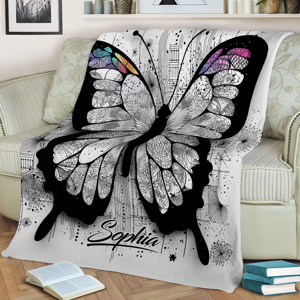 Large artistic butterfly blanket displayed on a sofa, featuring detailed wings and abstract black-and-white artwork