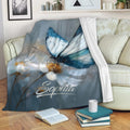 Blue butterfly and floral throw blanket draped over a cozy sofa with books and a cup
