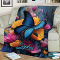 Blue butterfly blanket displayed on a sofa with bold painterly flowers and rich jewel tones