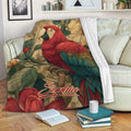 Parrot blanket draped over a sofa with colorful macaw and tropical floral artwork