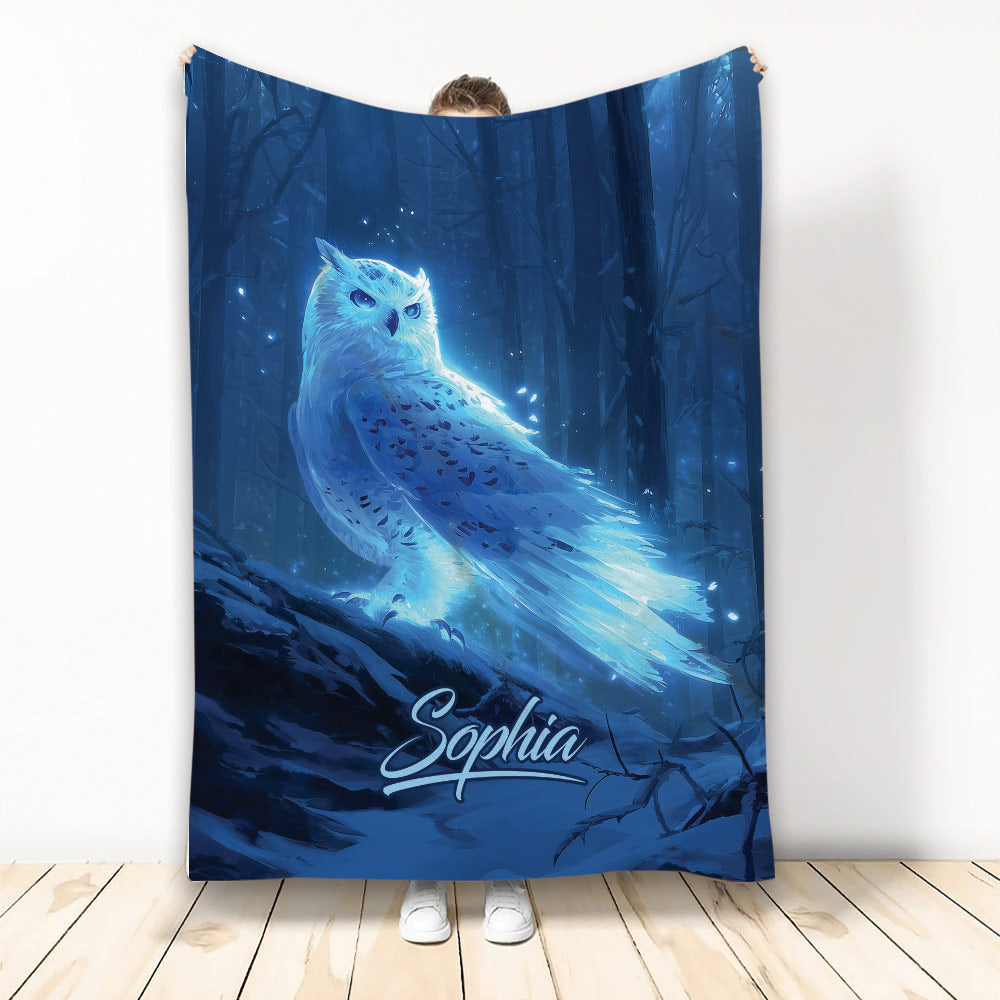 Blue glowing owl blanket displayed against a dark enchanted forest scene