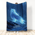 Blue glowing owl blanket displayed against a dark enchanted forest scene