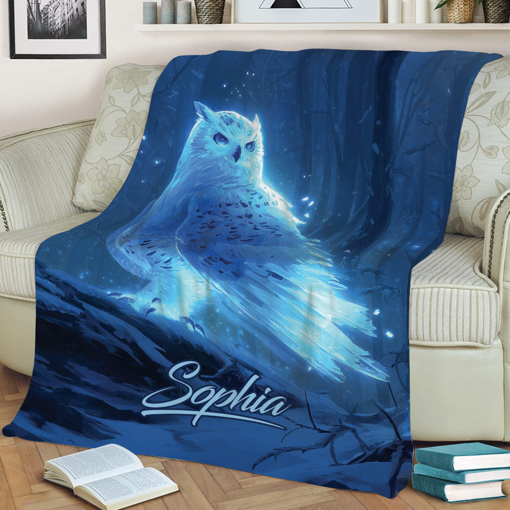 Enchanted blue owl blanket styled across a sofa with woodland artwork