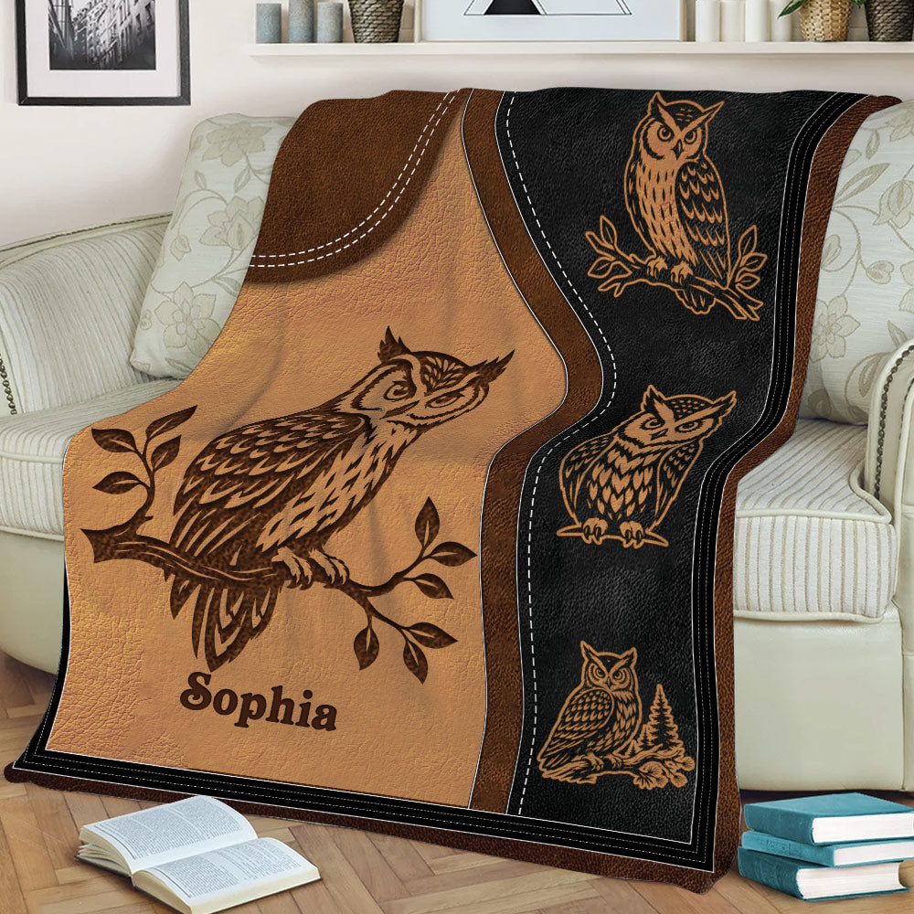 Close view of a rustic owl blanket draped over a sofa with detailed woodland bird artwork