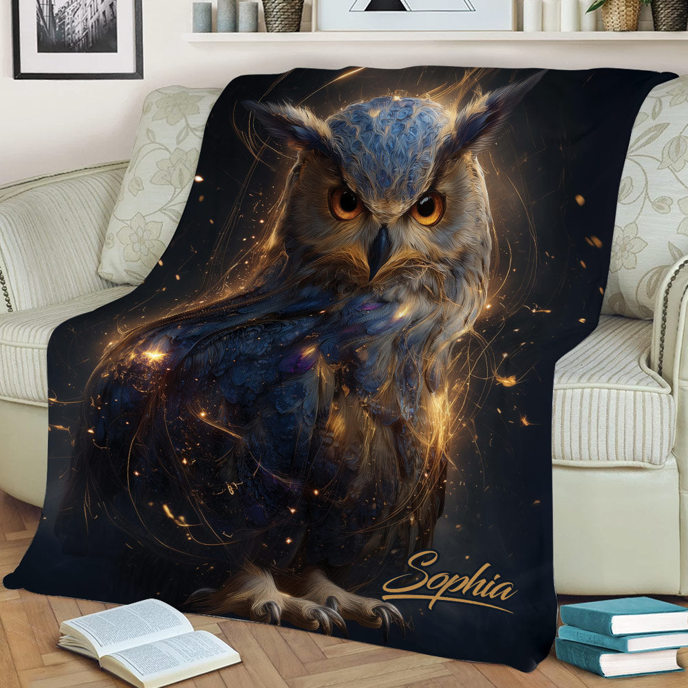 Close view of an artistic owl throw blanket styled across a sofa with rich blue and gold details