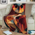 Abstract geometric owl throw blanket styled on a sofa with books nearby