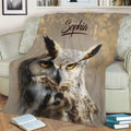 Detailed owl artwork on a throw blanket styled with books and a sofa for cozy home decor