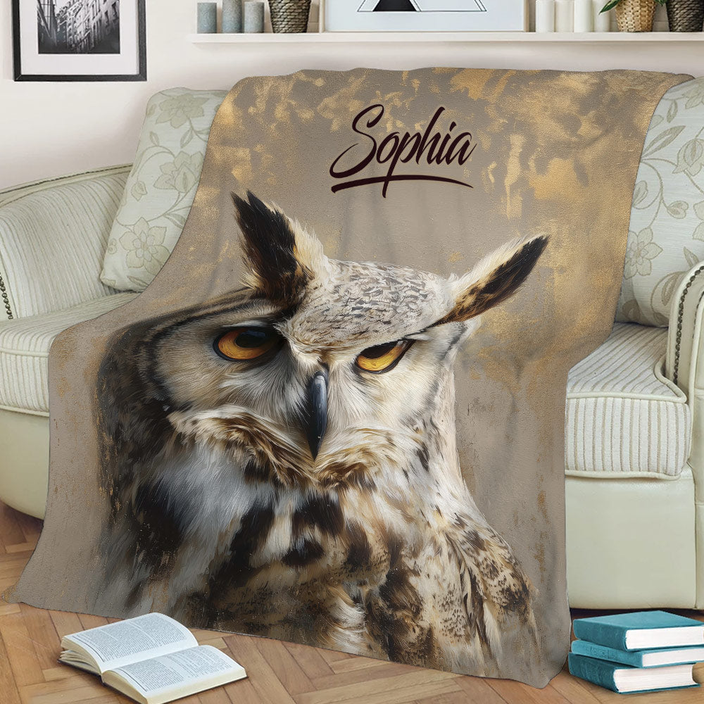 Detailed owl artwork on a throw blanket styled with books and a sofa for cozy home decor