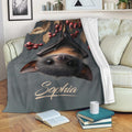 Bat throw blanket displayed on a sofa with woodland foliage and autumn berry artwork