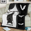 Black and white bat blanket styled across a sofa, featuring a large upside-down bat and flying bats