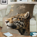 Close-up leopard throw blanket featuring detailed big cat artwork on a living room sofa