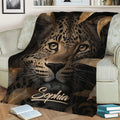 Close view of a leopard throw blanket styled on a sofa with rich brown and black artwork