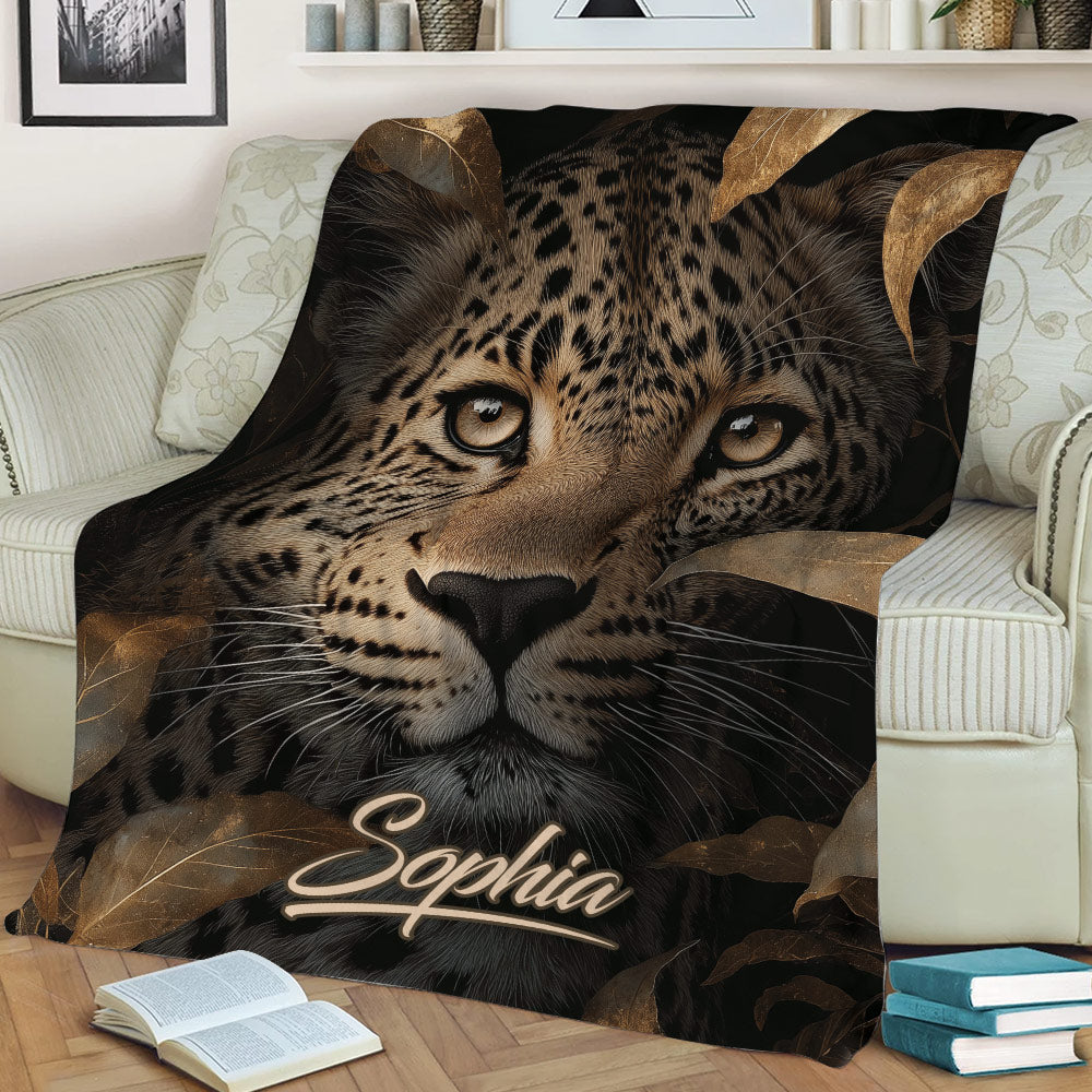 Close view of a leopard throw blanket styled on a sofa with rich brown and black artwork