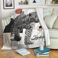 Black and white leopard throw blanket styled on a sofa with books and cozy living room decor