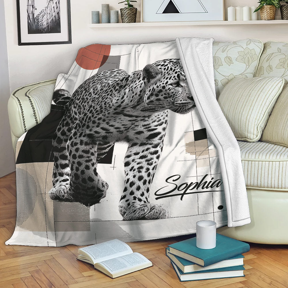 Black and white leopard throw blanket styled on a sofa with books and cozy living room decor