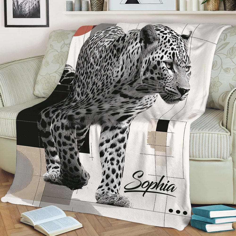 Modern leopard throw blanket draped over a sofa with bold wildlife artwork and geometric details