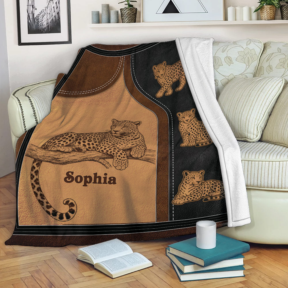 Leopard blanket draped over a sofa with reclining and cub leopard artwork in a cozy living room