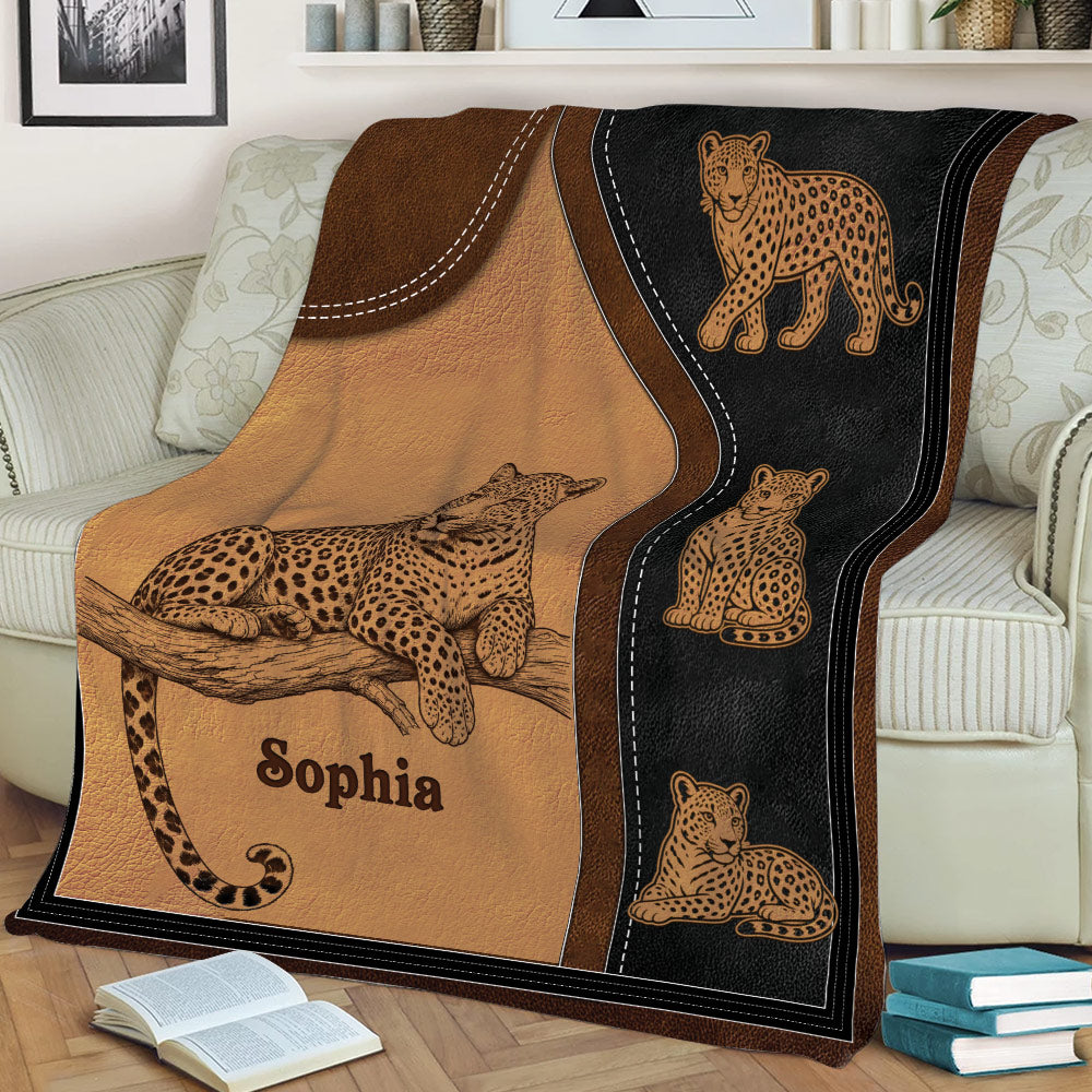 Close view of a leopard throw blanket displayed across a couch with detailed big cat illustrations