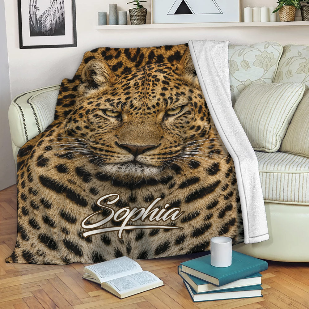 Leopard throw blanket draped over a sofa with realistic wildlife artwork