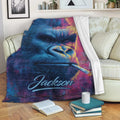 Gorilla throw blanket displayed on a sofa with vibrant blue, pink and yellow artwork