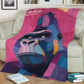 Bold abstract gorilla artwork blanket styled across a couch with books