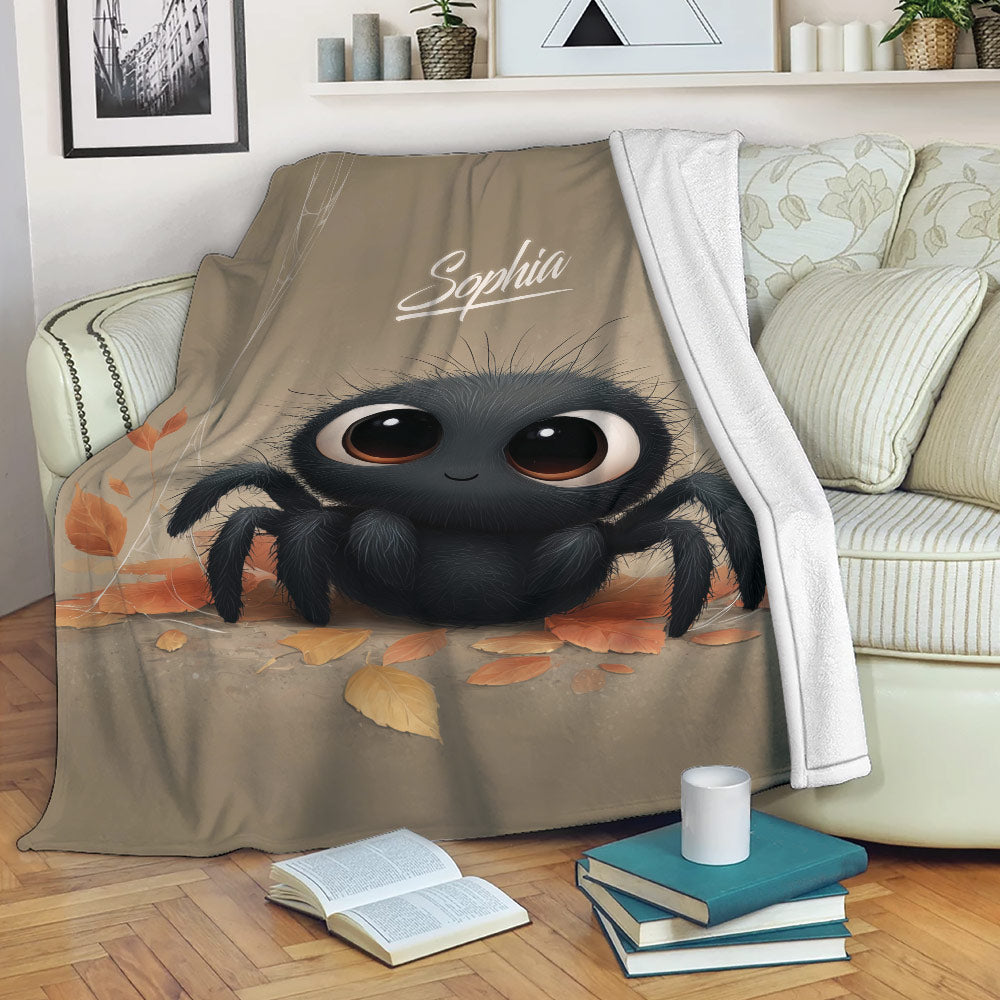 Cute black spider blanket draped over a sofa with autumn leaves and cozy reading nook decor