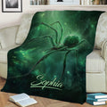Large green spider blanket styled across a sofa with glowing web-inspired artwork