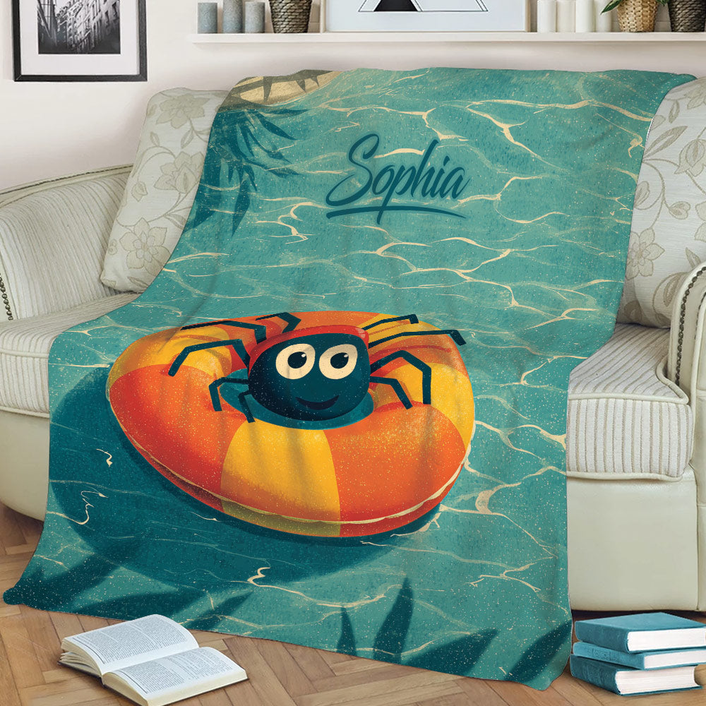 Cartoon spider blanket draped across a sofa, featuring teal water and orange pool ring artwork