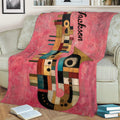 Abstract multicolor saxophone blanket styled across a sofa with books nearby
