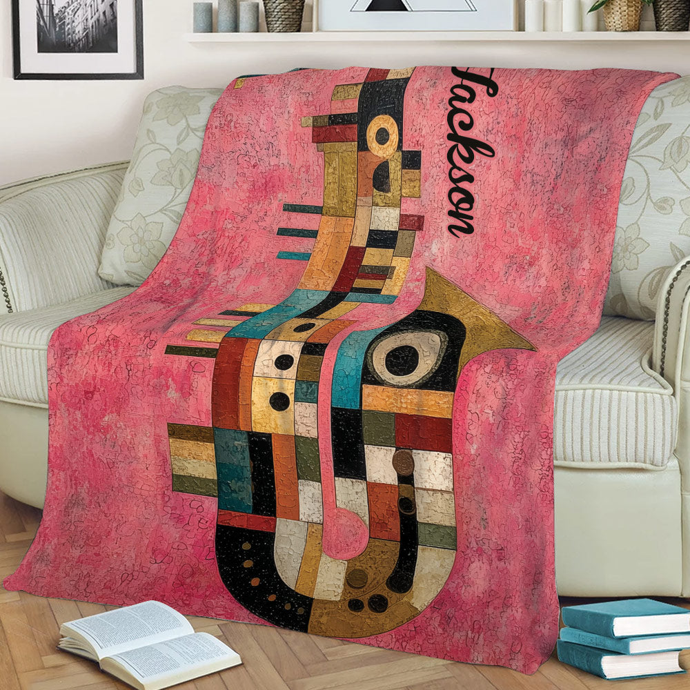 Abstract multicolor saxophone blanket styled across a sofa with books nearby