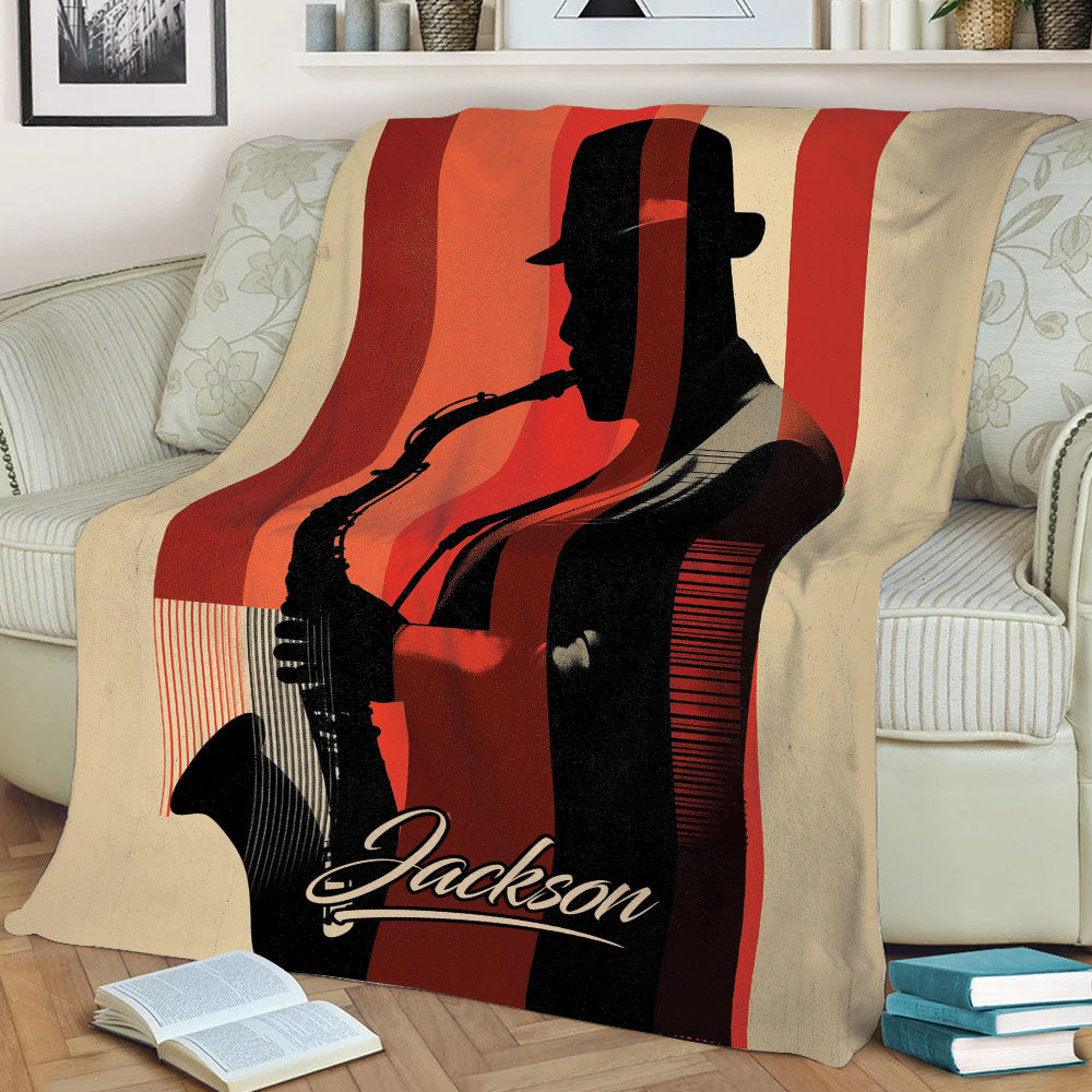Saxophone throw blanket displayed on a sofa with a bold silhouetted player and vintage striped artwork