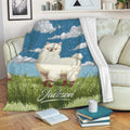 Llama blanket draped over a sofa with whimsical blue sky, cloud, and meadow artwork