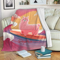Pink surfing llama throw blanket draped over a sofa in a cozy living room