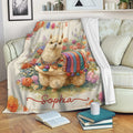Floral llama throw blanket displayed across a sofa in a cozy living room